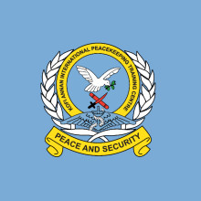 Front view of the KAIPTC main building with flags and entrance gate